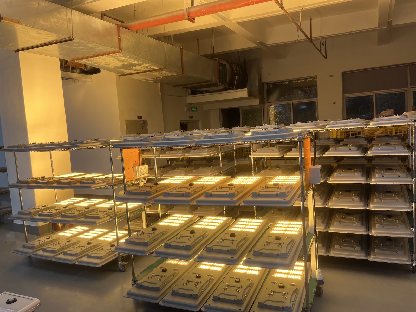 Aging test room with finished solar LED street lights powered on for 8-hour burn-in before shipment
